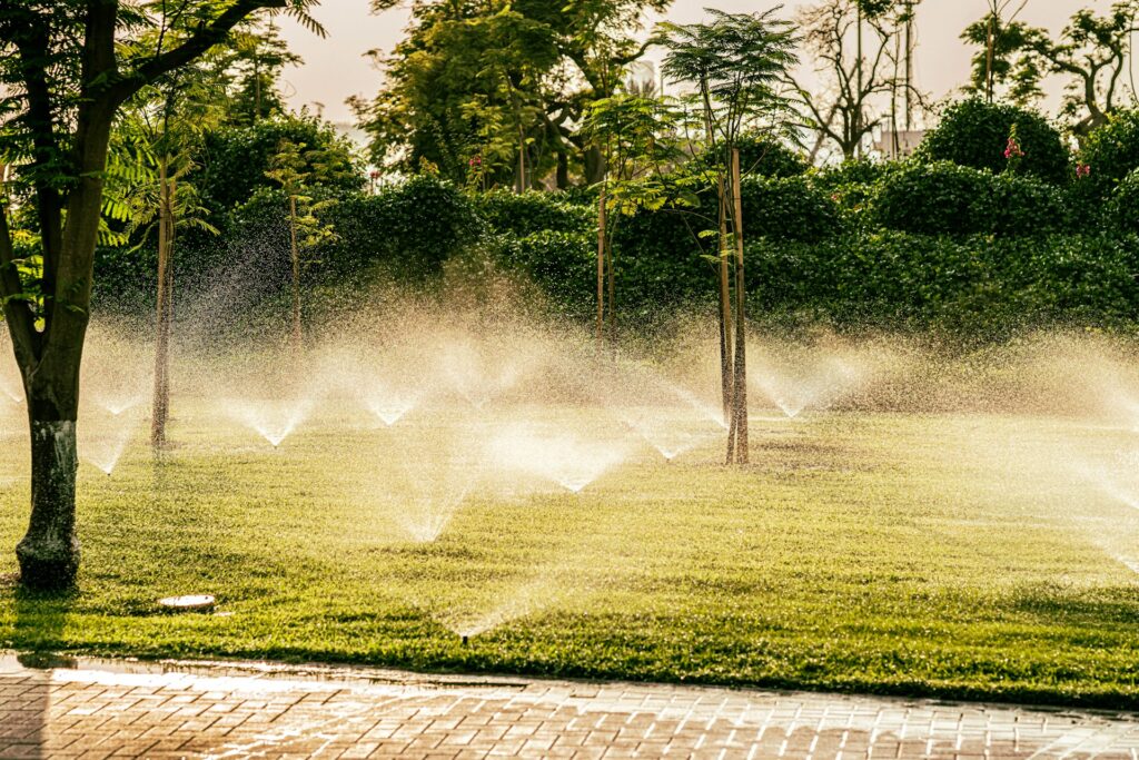 Water sprinkler providing full coverage on a green lawn