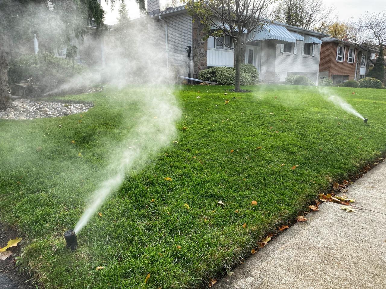 Sprinkler system being blown out during irrigation winterization